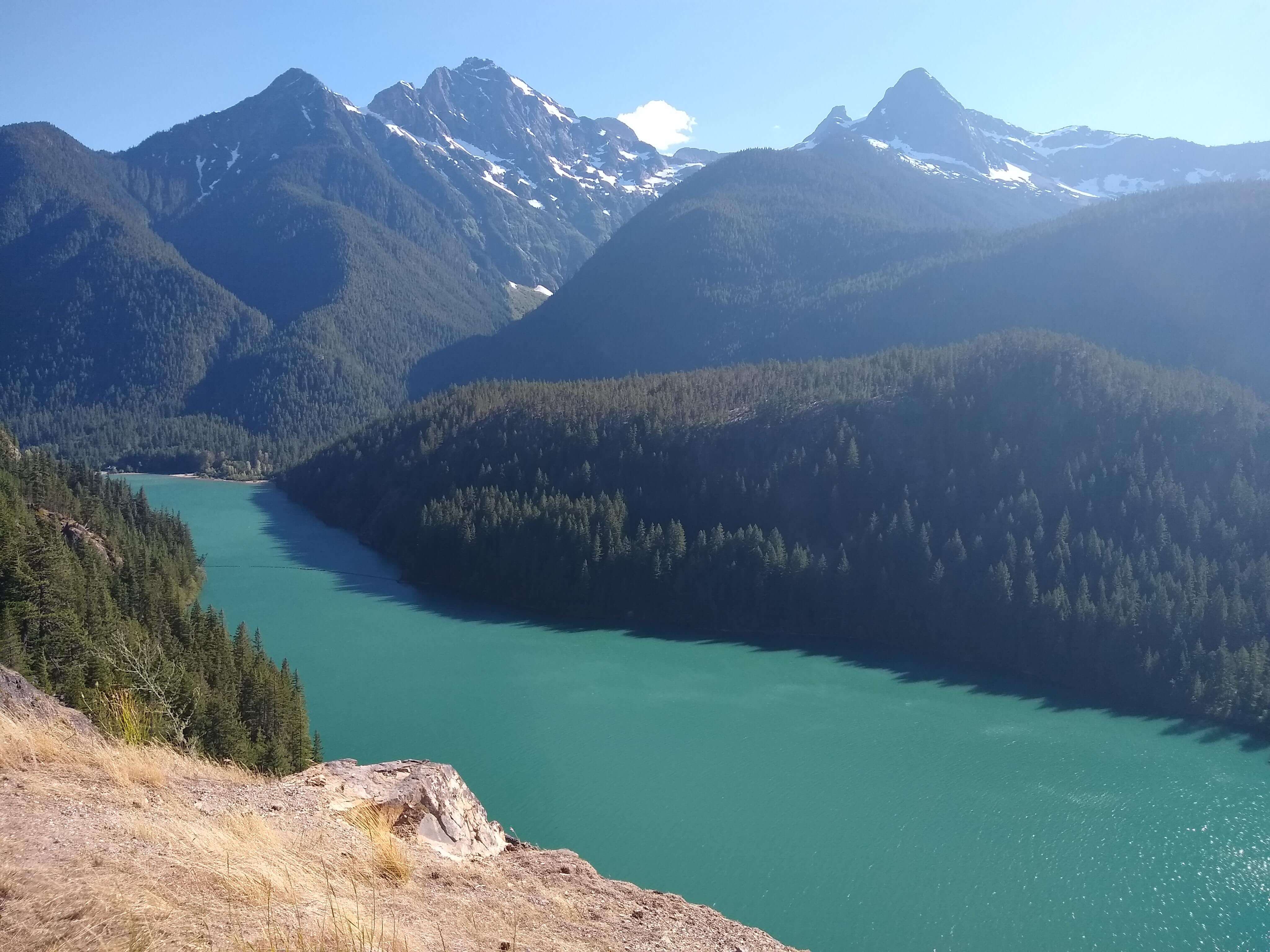 Sharp mountain peaks tower above turquoise water in North Cascades National Park