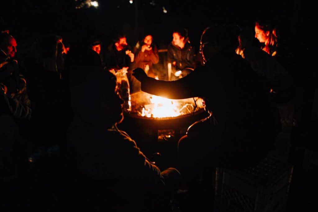 A large group of people sitting around a campfire