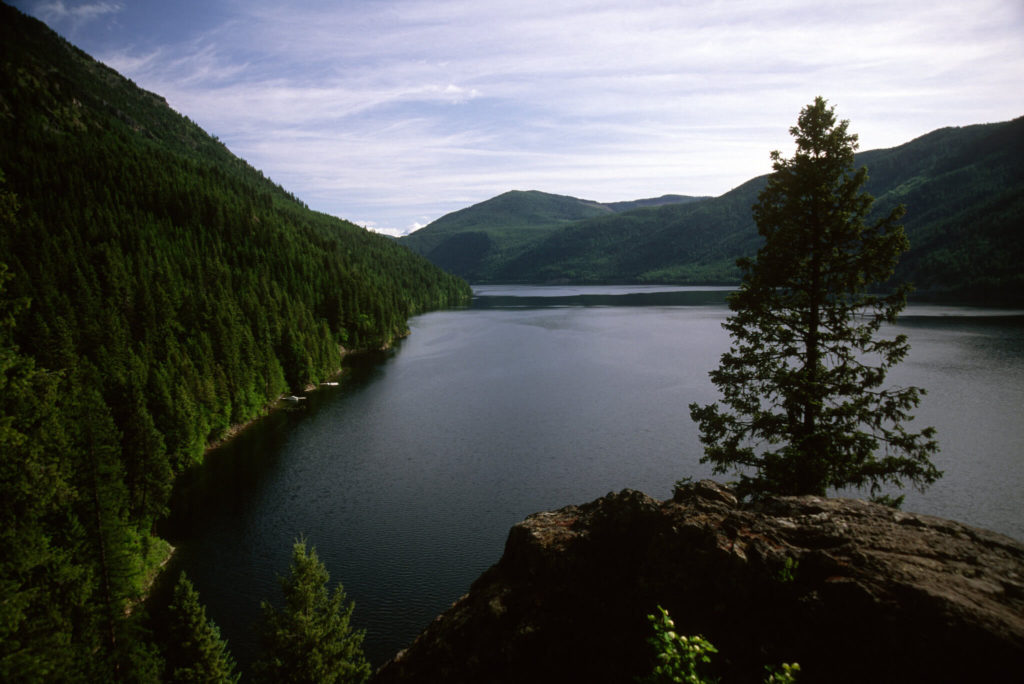 A dark lake surrounded by dark green hills