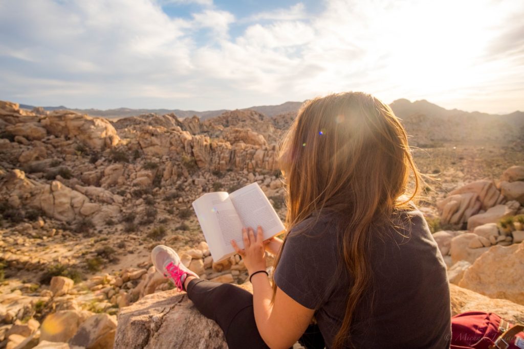 A woman sitting and reading in a desert national park
