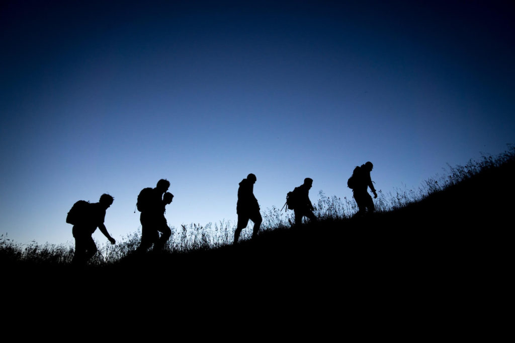 A silhouette of five hikers