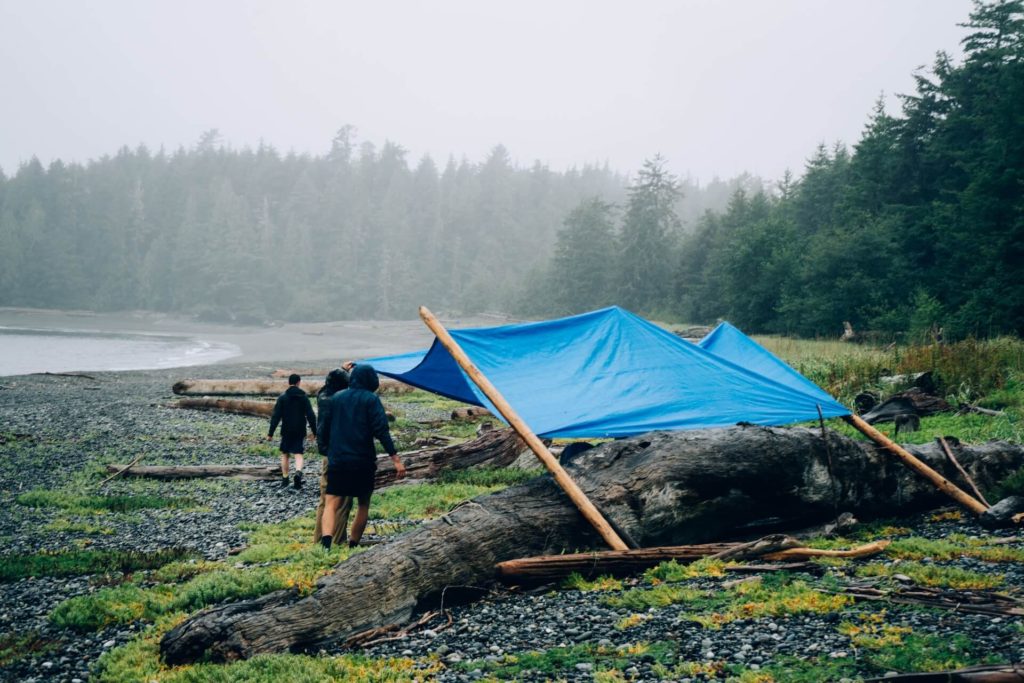 Blue tarp providing shelter on a rainy beach